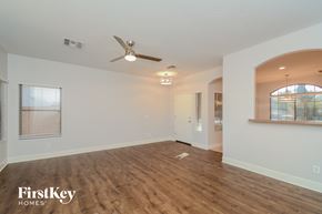 El Mirage house for rent - A spacious room with wooden flooring and a ceiling fan.
