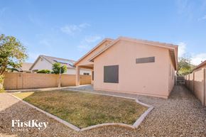 El Mirage house for rent - A modern house with a pink exterior and a gravel driveway.