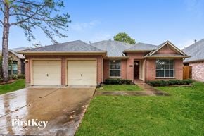 Houston house for rent - A brick house with a garage door is for sale.