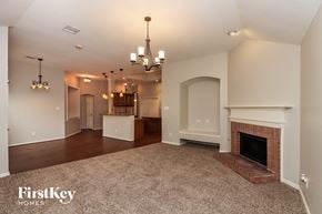 Houston house for rent - A spacious living room with a fireplace and a chandelier.
