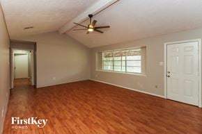 Houston house for rent - an empty living room with wood floors and a ceiling fan