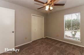Houston house for rent - a bedroom with a ceiling fan and a window