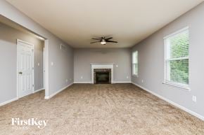 Lake St Louis house for rent - A spacious room with a fireplace and a ceiling fan.