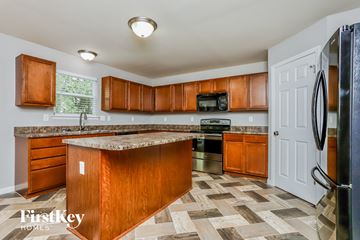 Lake St Louis house for rent - A kitchen with wooden cabinets and a tiled floor.