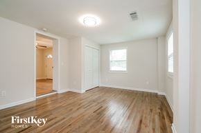 Covington house for rent - the living room and dining room with wood flooring and white walls