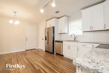 Covington house for rent - a kitchen with white cabinets and a stainless steel refrigerator