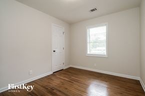 Covington house for rent - the upstairs bedroom with hardwood flooring and a white door