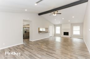 Fort Worth house for rent - A spacious room with wooden flooring and a ceiling fan.