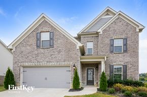 Cumming house for rent - a brick house with a garage door on a driveway