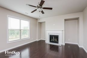 Cumming house for rent - a living room with a fireplace and a ceiling fan