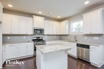 Cumming house for rent - a white kitchen with white cabinets and a counter top