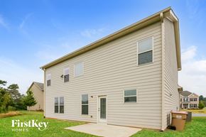 Cumming house for rent - the outside of a white house with a driveway and grass