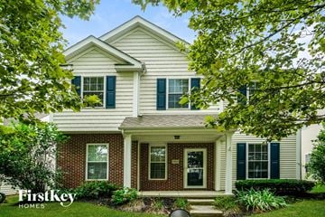 Westerville house for rent - a white house with blue shutters and a lawn and trees