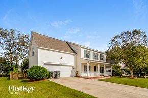 Summerville house for rent - A white house with a brown roof and a garage door.