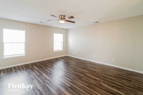 Summerville house for rent - A spacious room with wooden floors and a ceiling fan.
