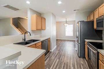Summerville house for rent - A kitchen with wooden cabinets and black appliances.