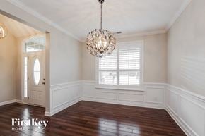 Mooresville house for rent - an empty dining room with a large window and a chandelier