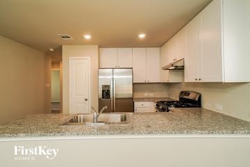 San Antonio house for rent - a kitchen with white cabinets and a granite counter top