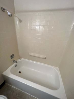 Fargo apartment for rent - A white bathtub in a bathroom with a shower head.