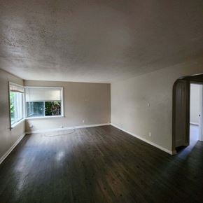 Longview house for rent - an empty living room with a window and wooden floors
