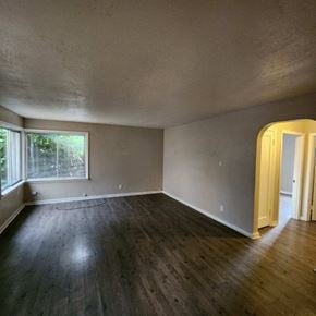 Longview house for rent - an empty living room with wood floors and a window
