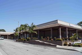 Covina apartment for rent - a building with palm trees and a street in front of it
