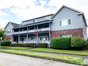 Longview apartment for rent - A grey building with a red and white sign in front.