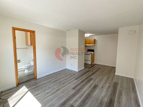 Longview apartment for rent - A room with wooden flooring and a white wall with a doorway leading to another room.