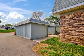 Maplewood townhouse for rent - the driveway of a house with a brick wall and a gray garage