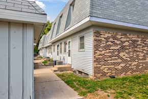 Maplewood townhouse for rent - a side view of a white and brick house with a sidewalk