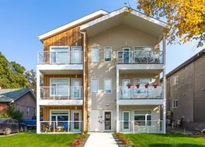 Winnipeg apartment for rent - A modern two-story apartment building with balconies and a clear blue sky above.