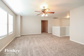 Spring house for rent - a spacious living room with carpet and a ceiling fan