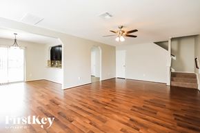 Rosenberg house for rent - A spacious room with wooden floors and a ceiling fan.