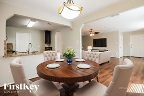 Rosenberg house for rent - A dining room with a wooden table and chairs.