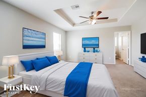 Rosenberg house for rent - A bedroom with a large bed and a ceiling fan.
