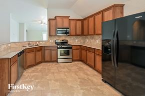 Cypress house for rent - a kitchen with wooden cabinets and stainless steel appliances