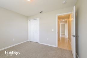 Kissimmee house for rent - a bedroom with a hallway and a door to a closet