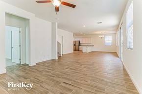 Mesa house for rent - an empty living room and kitchen with a ceiling fan
