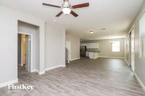 Mesa house for rent - A spacious room with a ceiling fan and light fixture.