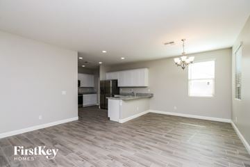 Mesa house for rent - A spacious kitchen and living room with wood flooring and a chandelier.
