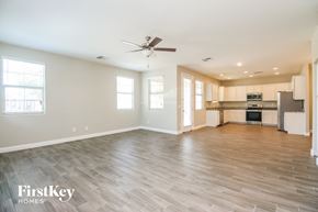 Mesa house for rent - an empty living room and kitchen with wood flooring and a ceiling fan