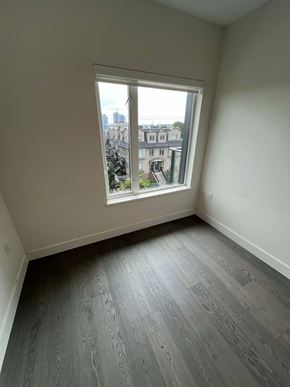 Vancouver apartment for rent - A room with a window overlooking a cityscape.