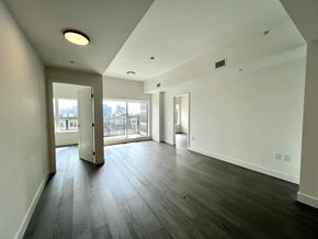 Vancouver apartment for rent - A spacious room with a view of the city through the windows.