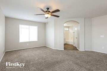 Peoria house for rent - a living room with carpet and a ceiling fan