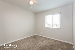 Peoria house for rent - a bedroom with carpet and a window and a ceiling fan