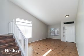 Laveen house for rent - an empty living room with a staircase and a white door