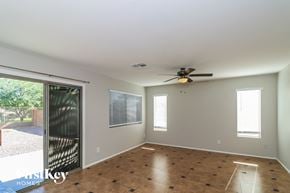 Laveen house for rent - an empty living room with a ceiling fan and a sliding glass door