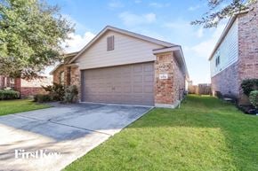 Baytown house for rent - a garage door in front of a brick house