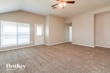 Baytown house for rent - a spacious living room with carpet and a ceiling fan