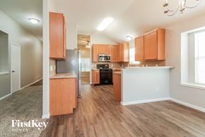 Baytown house for rent - an open kitchen and living room with wood flooring and wooden cabinets